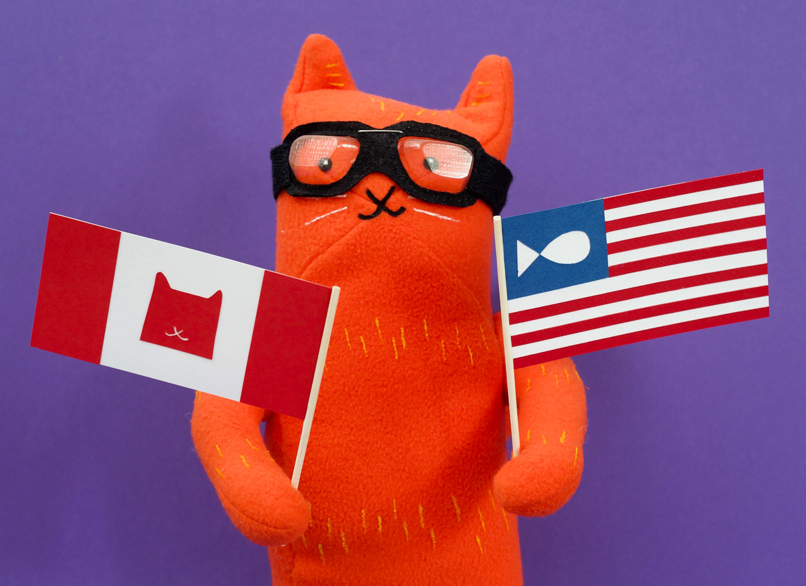 Plush Asta from Alley Cat Rally holding Canadian and USA flags